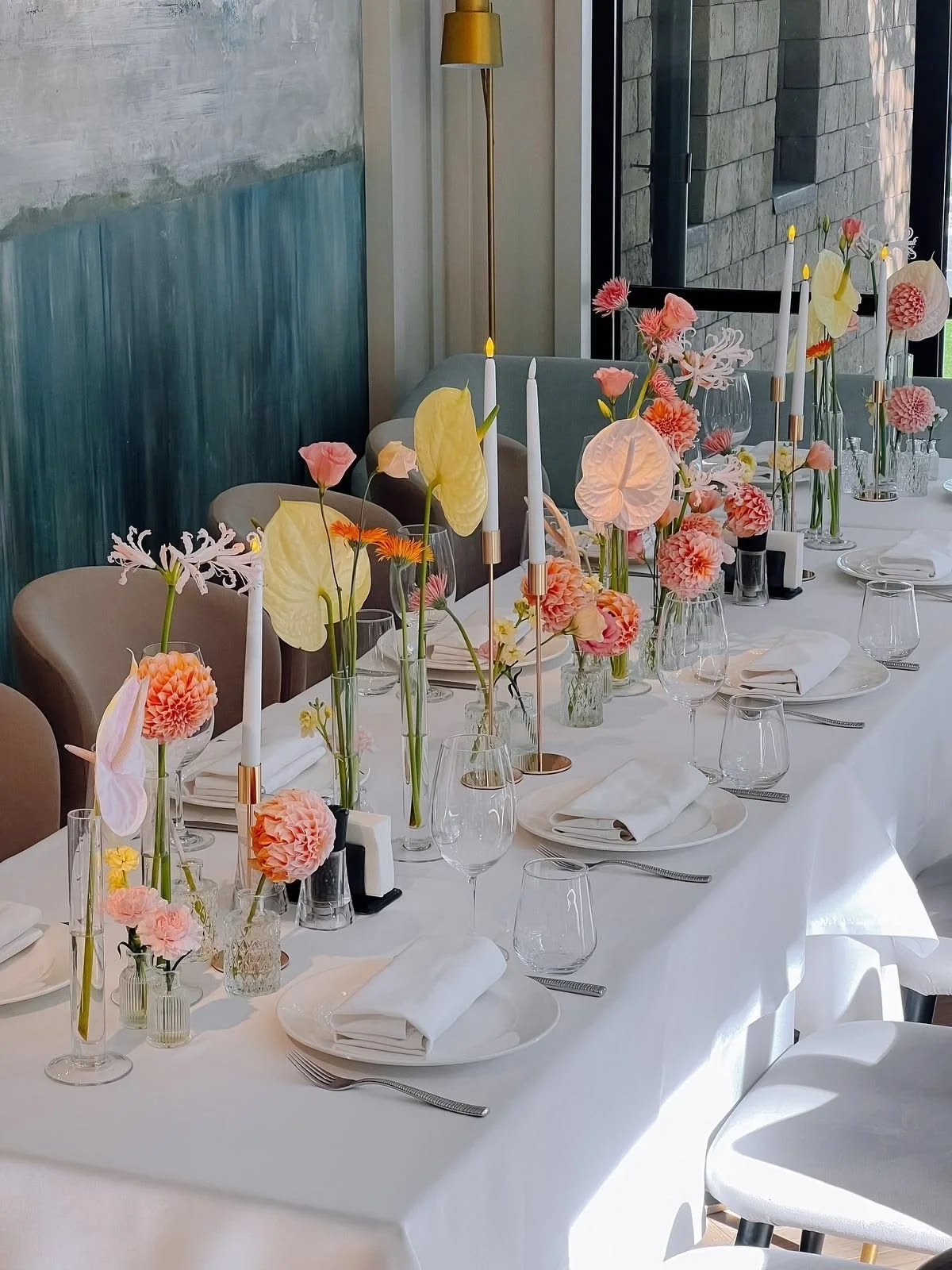 Pastel long dinner table with bud vases and candles